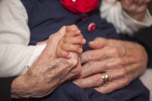 Baby and grandmother holding hands